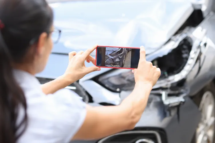 A person taking picture of the car accident for evidence.