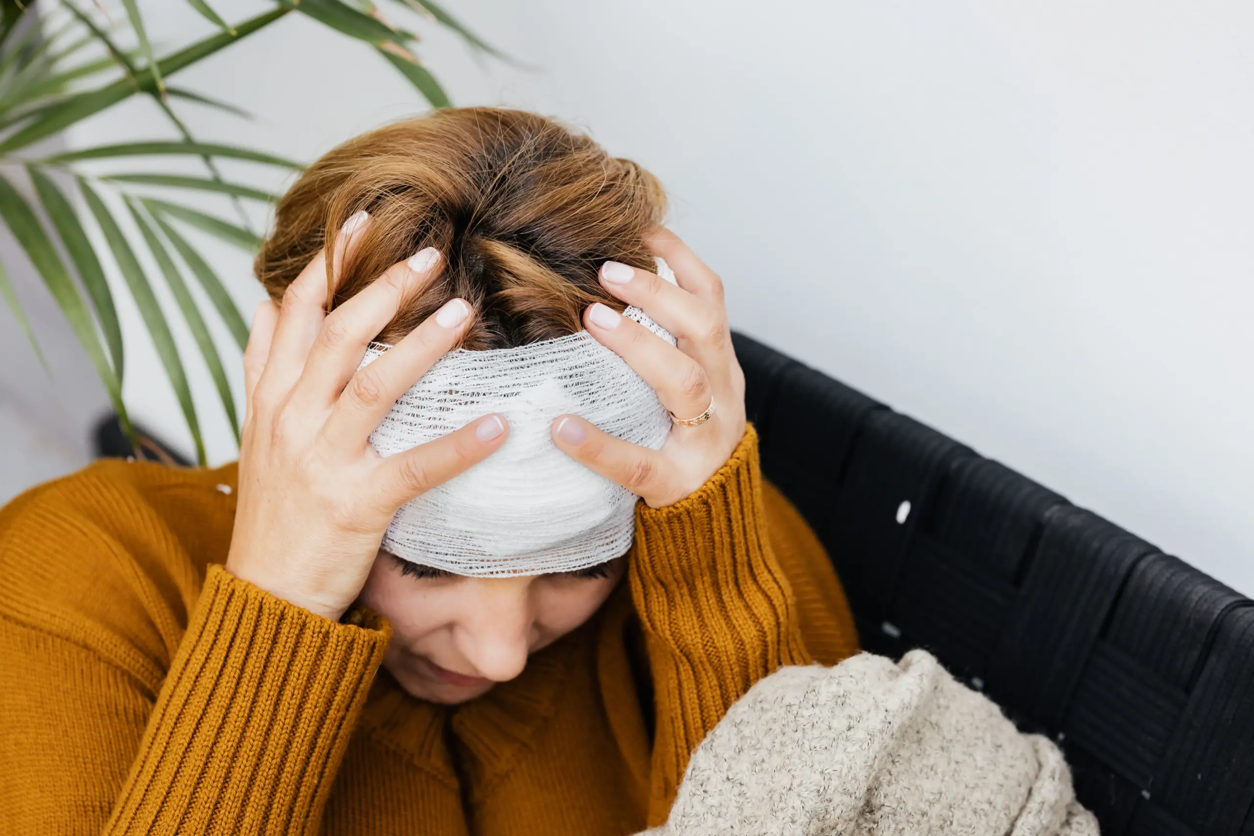 A woman holding her head after a brain injury.