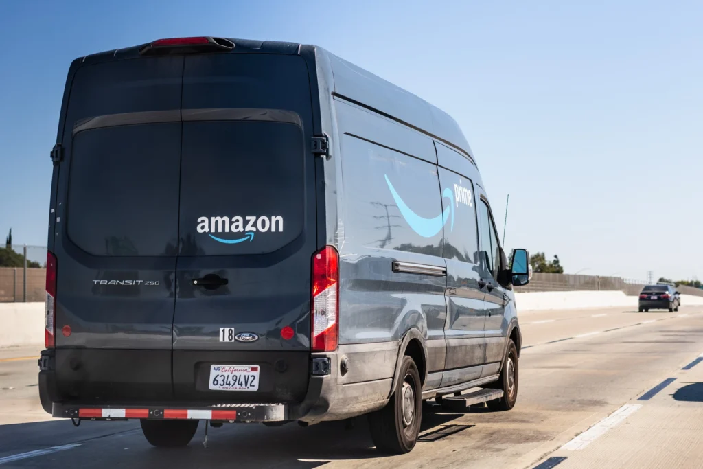 An Amazon delivery vehicle driving on the highway.