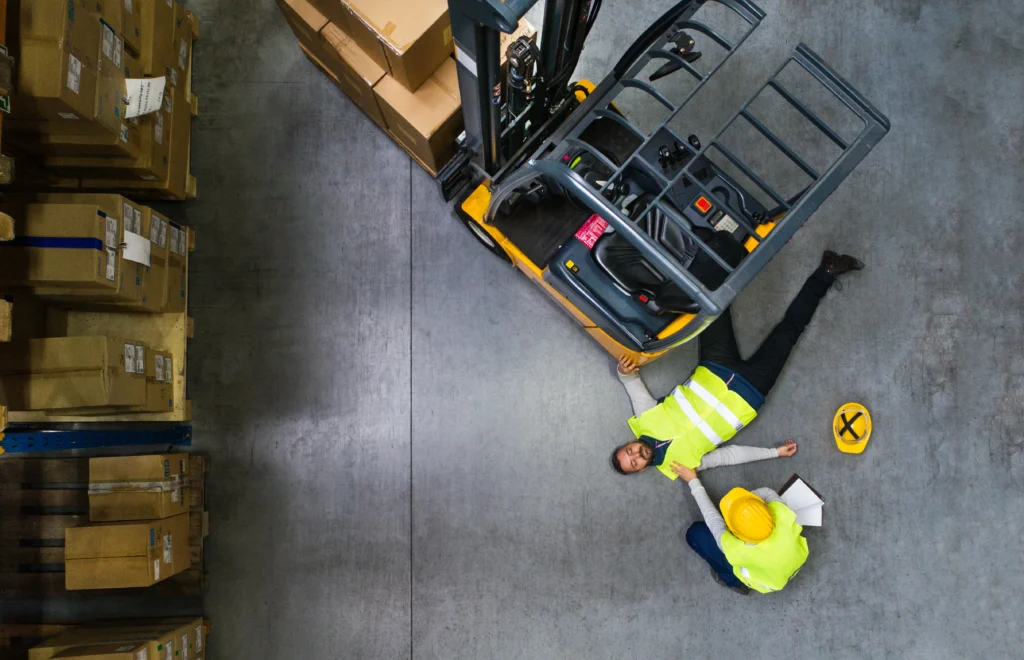 Two workers, one pinned under a forklift.