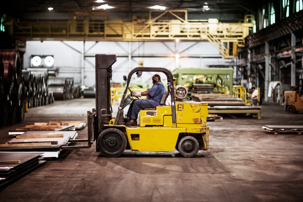 Man driving a forklift in a warehouse.