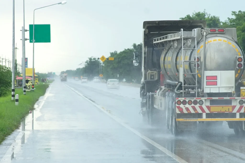 A truck driving on the highway in poor weather conditions.