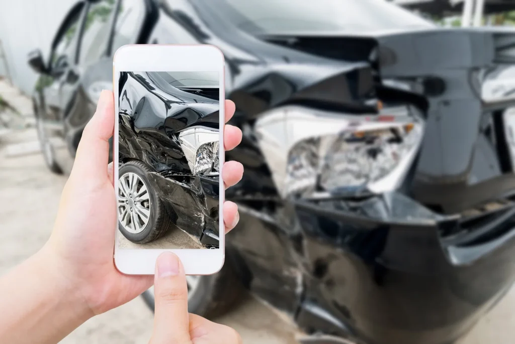 Someone taking a picture of their damaged car.