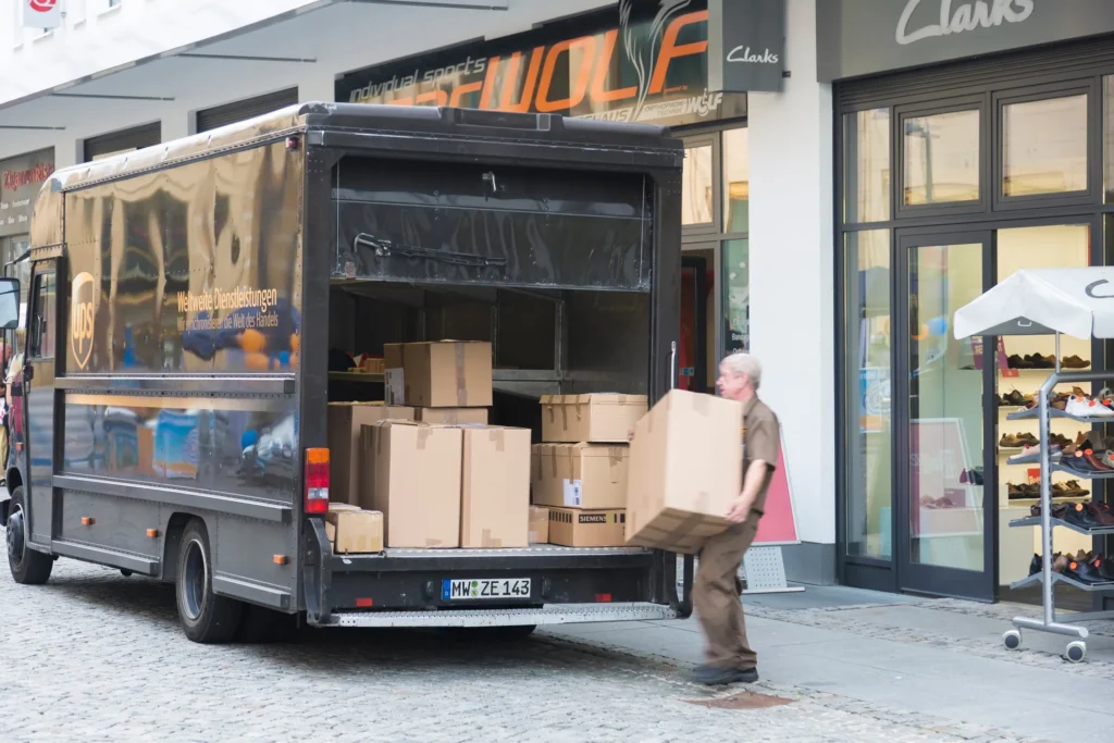 A man loading up a delivery truck with boxes.