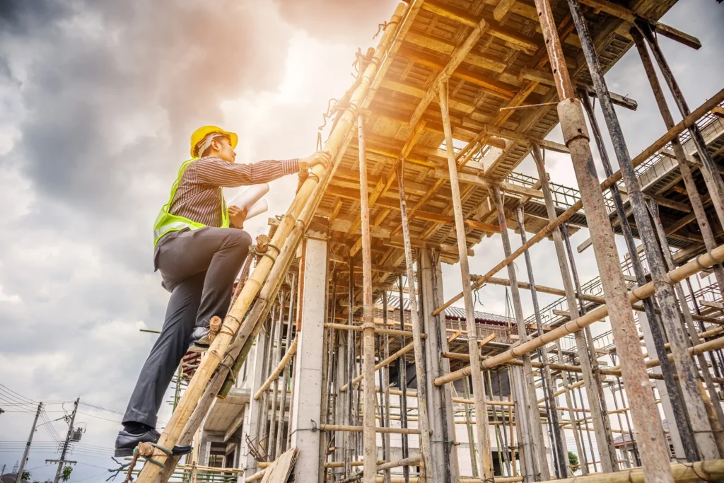 A construction worker concerned about falling from heights while standing on a ladder.
