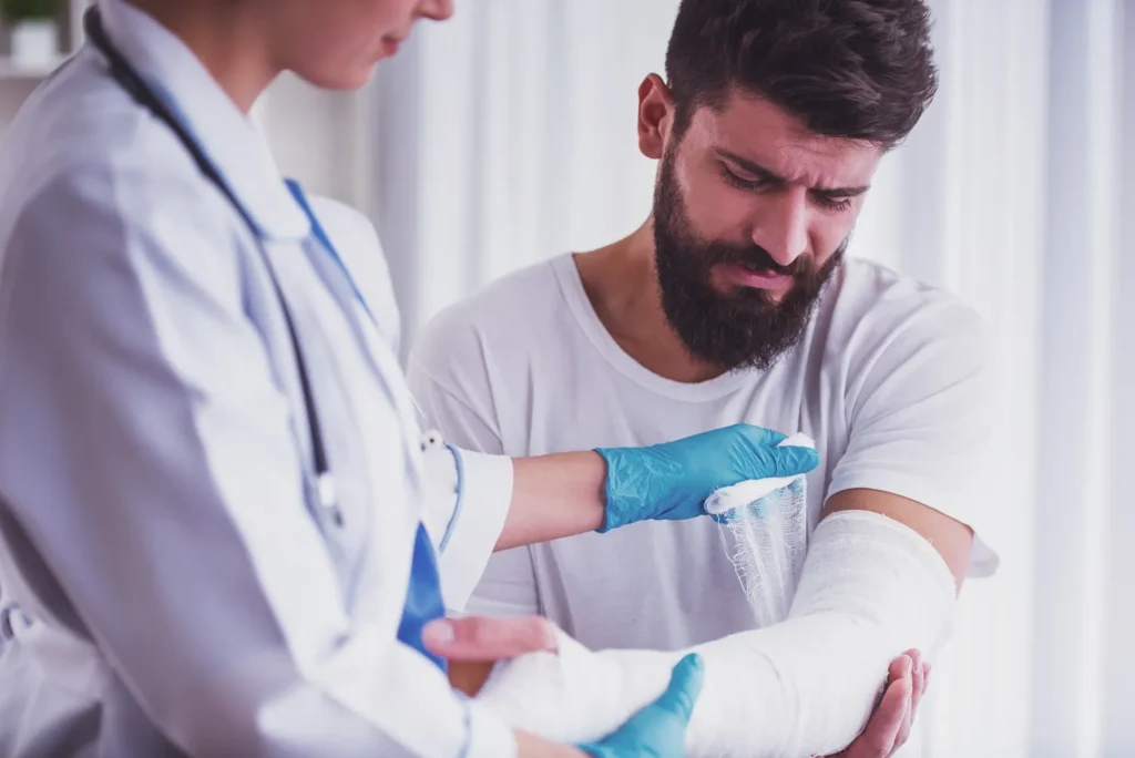 A doctor looking at a broken arm after a fall accident.