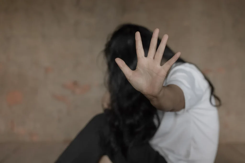 A distressed person shielding their face with an outstretched hand—an image illustrating privacy, consent, and the types of evidence needed to support a sexual assault lawsuit in Texas.
